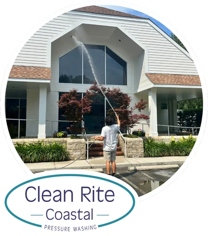 Clean Rite Coastal Image with Logo (2) Person pressure washing a modern building facade, standing on a sidewalk. Clean Rite Coastal logo. Pressure washing Wilmington NC.